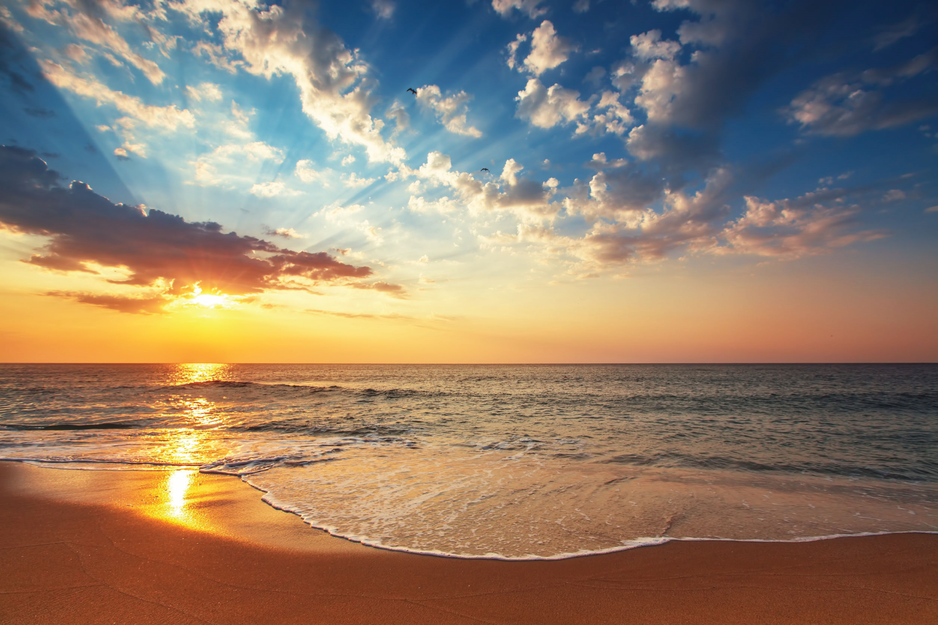 Ocean waves on beach with orange sunset